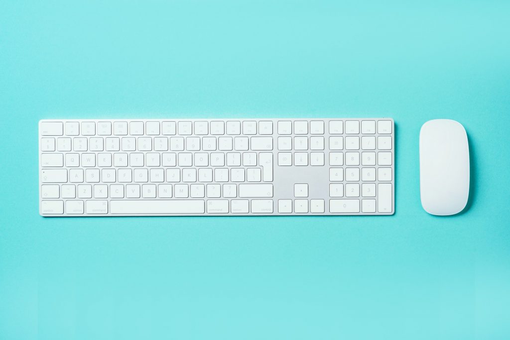 White mouse and keyboard on blue background. Top view. Copy space. Flat lay. Remote job, work. Home